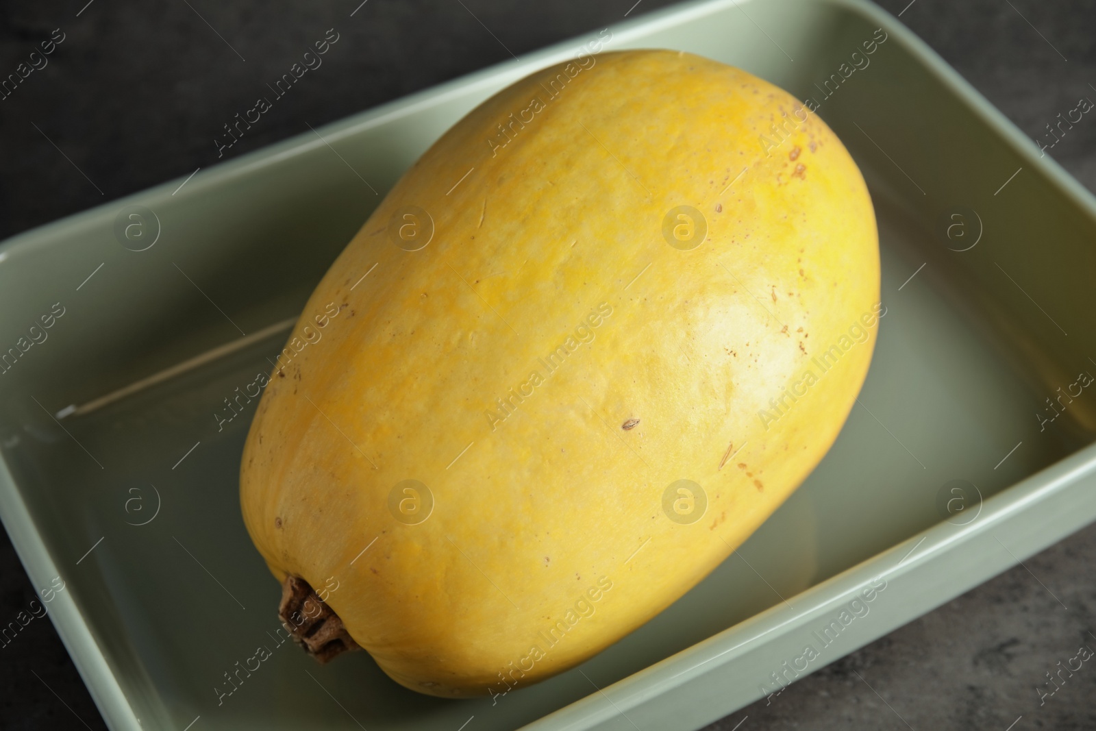 Photo of Baking dish with spaghetti squash on gray table