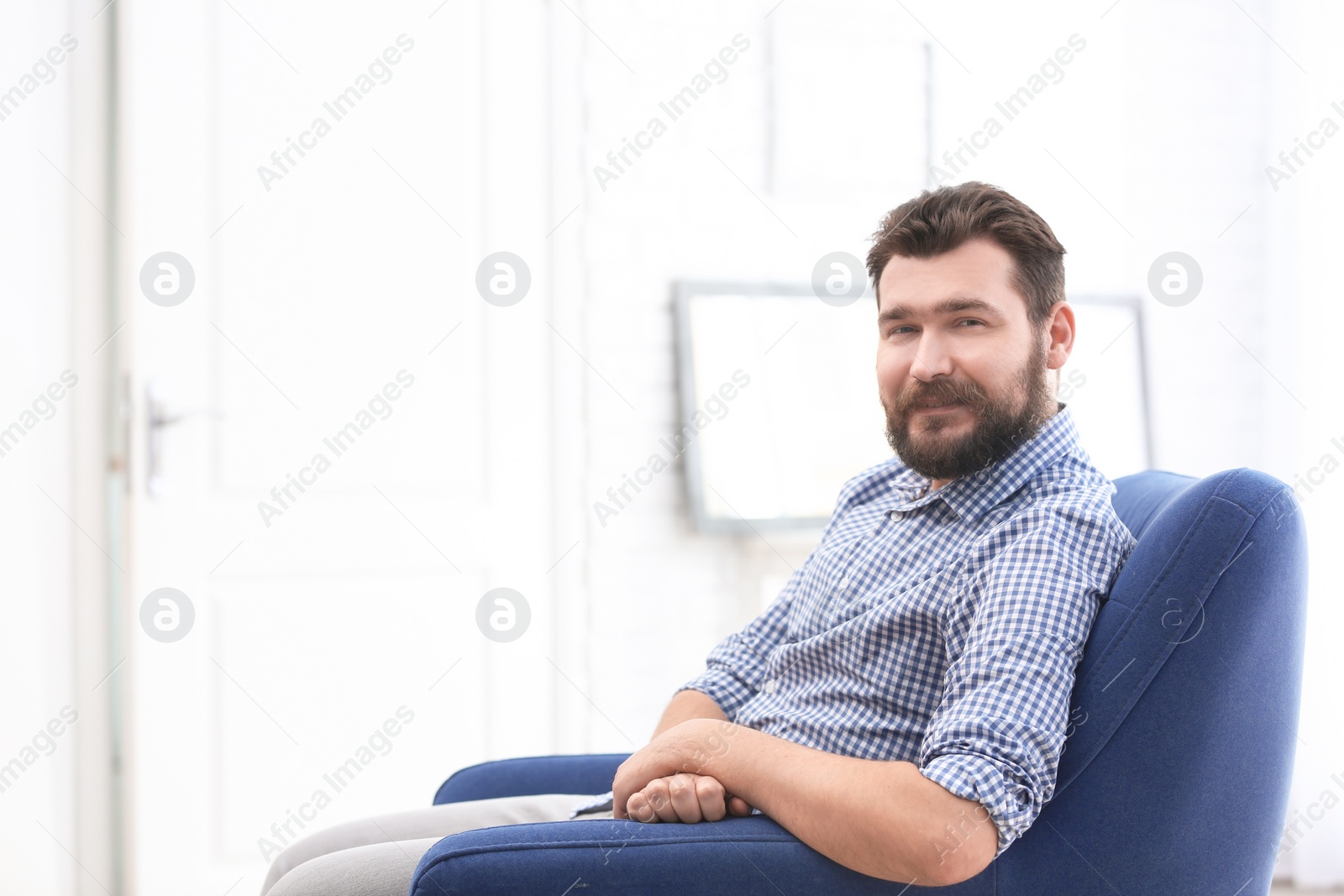 Photo of Portrait of confident mature man in armchair