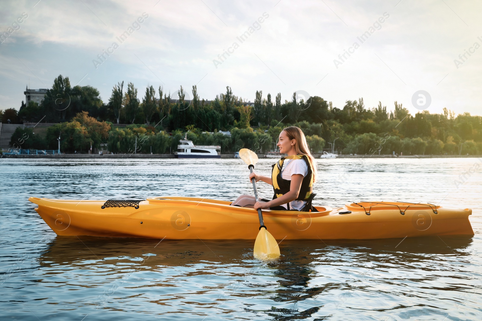 Photo of Beautiful young woman kayaking in river. Summer activity