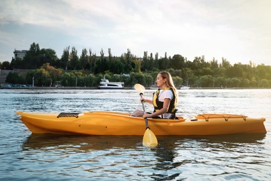 Photo of Beautiful young woman kayaking in river. Summer activity