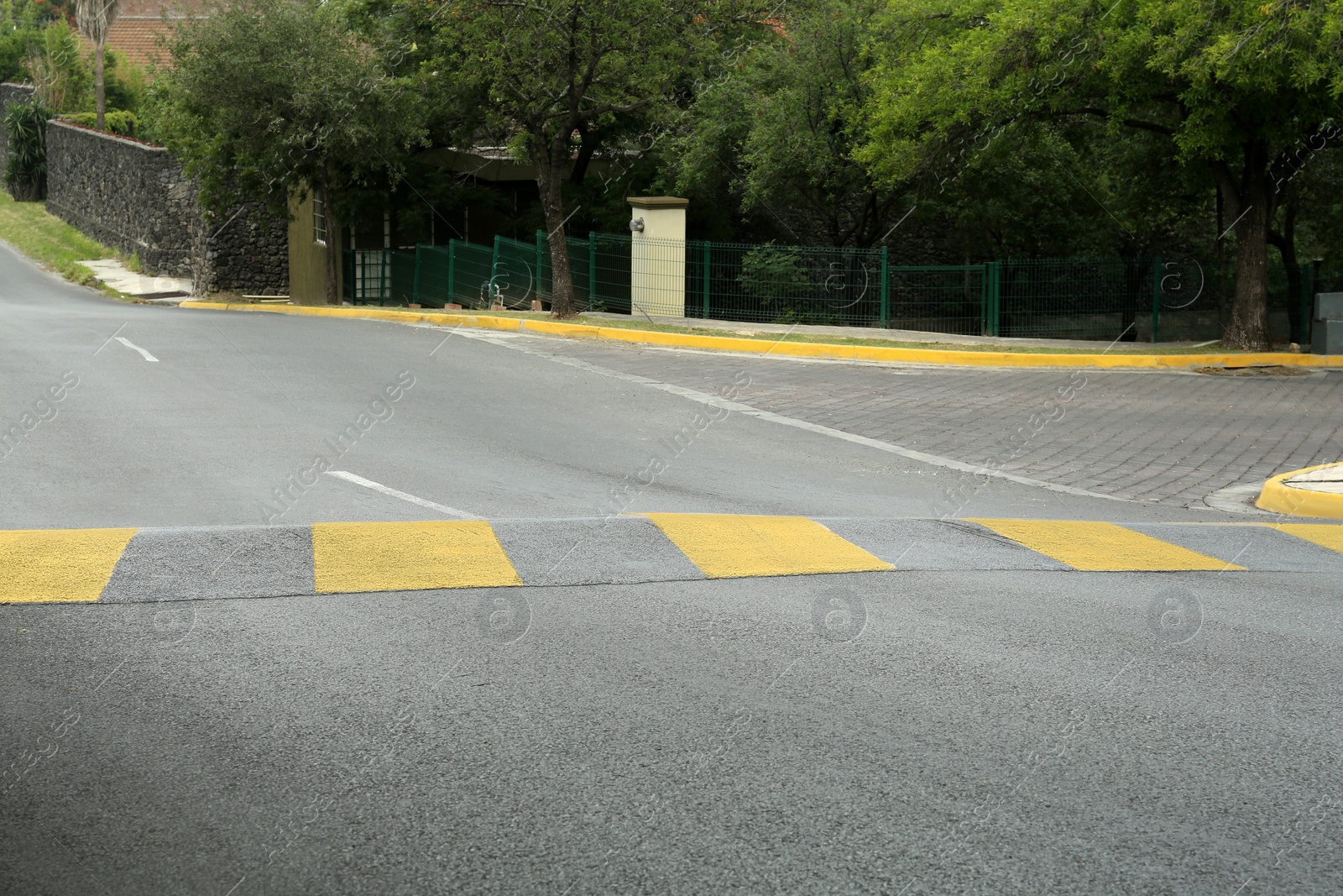 Photo of City street with striped concrete speed bump