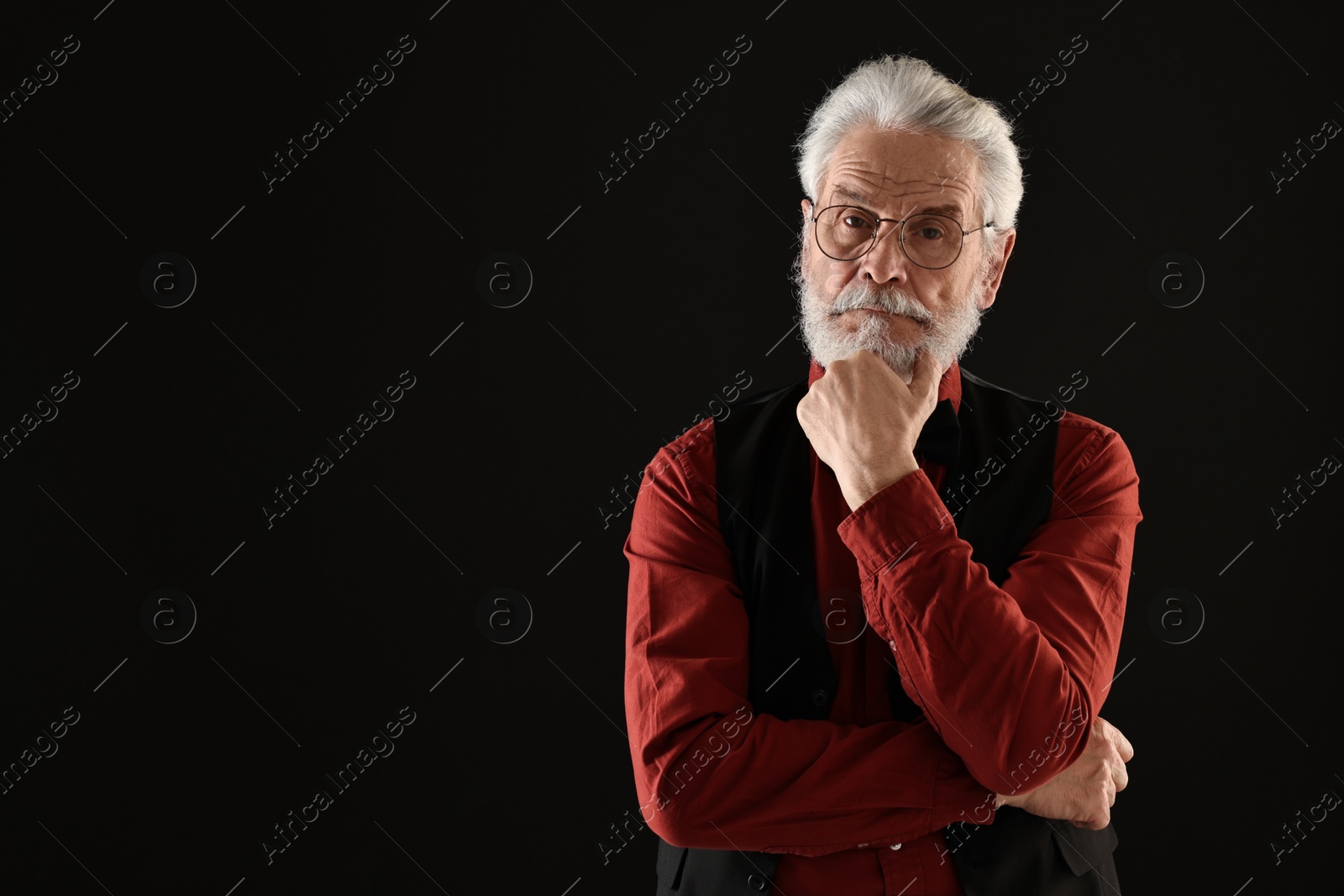 Photo of Senior man with mustache on black background, space for text