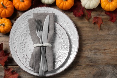 Photo of Happy Thanksgiving day. Beautiful table setting, autumn leaves and pumpkins on wooden background, flat lay with space for text