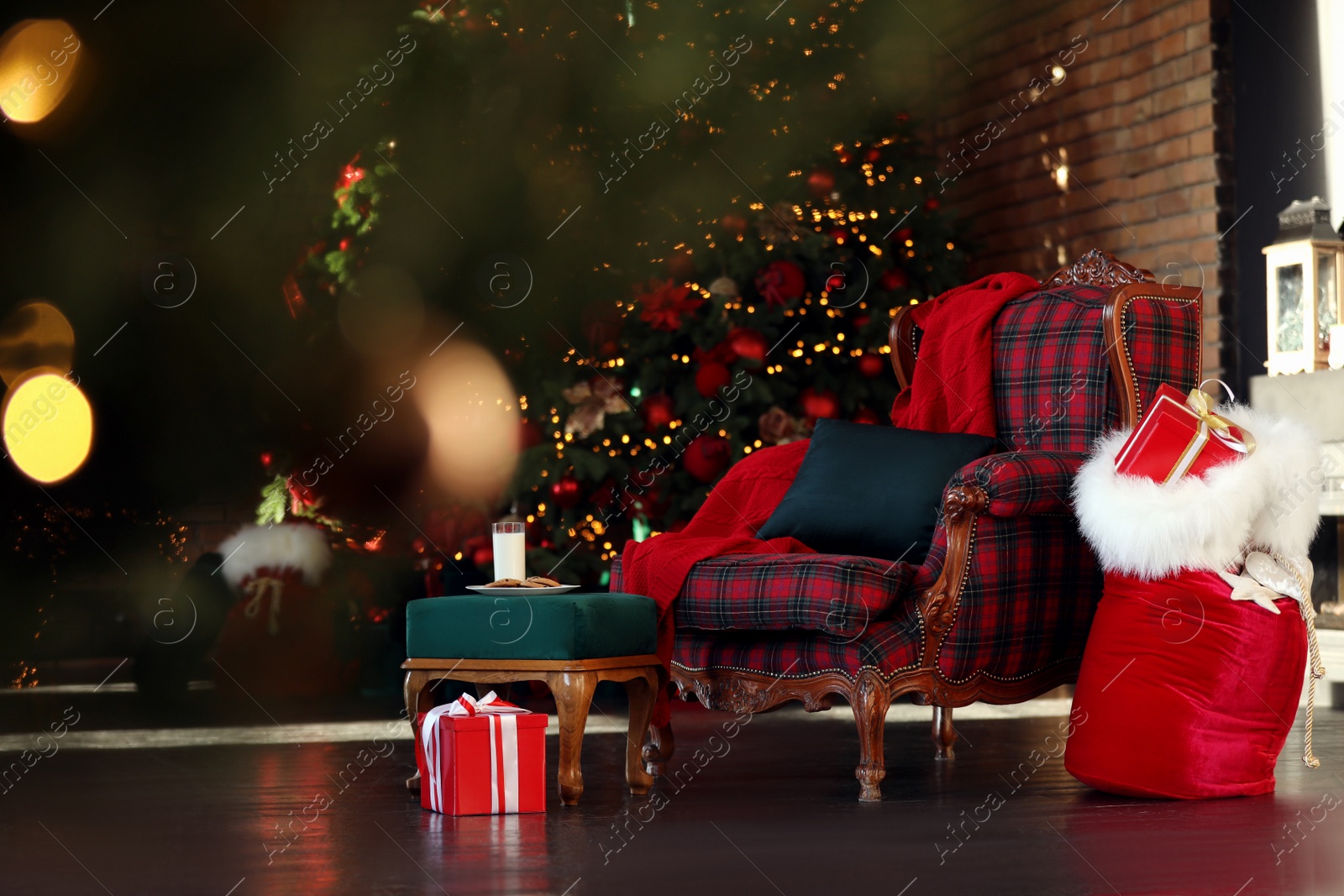 Photo of Santa Claus bag near armchair in room with Christmas tree