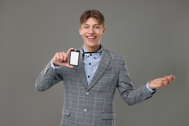 Photo of Happy man with blank badge on grey background