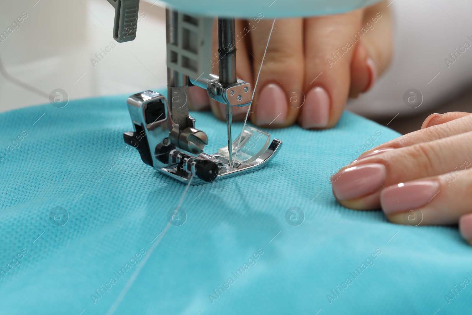 Photo of Seamstress working with sewing machine indoors, selective focus