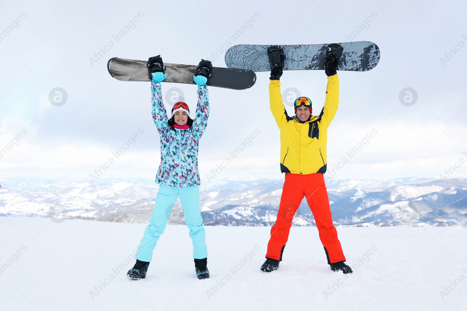 Photo of Lovely couple with snowboards on hill. Winter vacation
