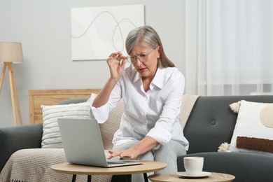 Photo of Beautiful senior woman using laptop at home