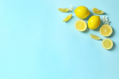 Photo of Frame made of lemons and flowers on color background, flat lay with space for text. Citrus fruits