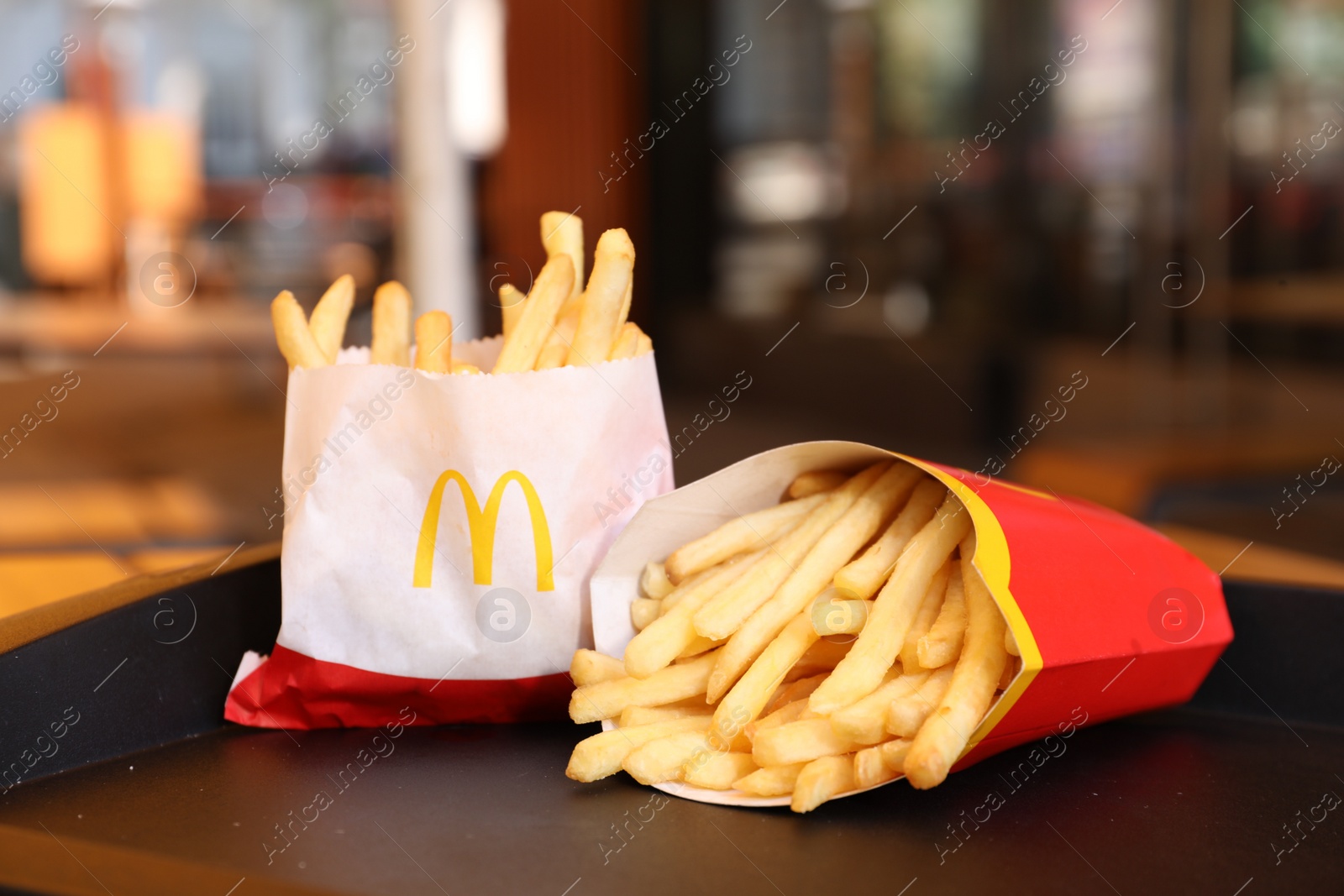 Photo of MYKOLAIV, UKRAINE - AUGUST 11, 2021: Big and small portions of McDonald's French fries on tray in cafe