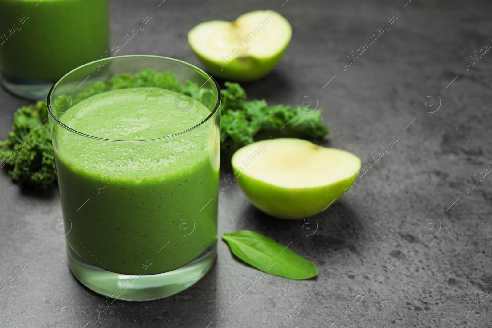 Photo of Tasty fresh kale smoothie on grey table, closeup