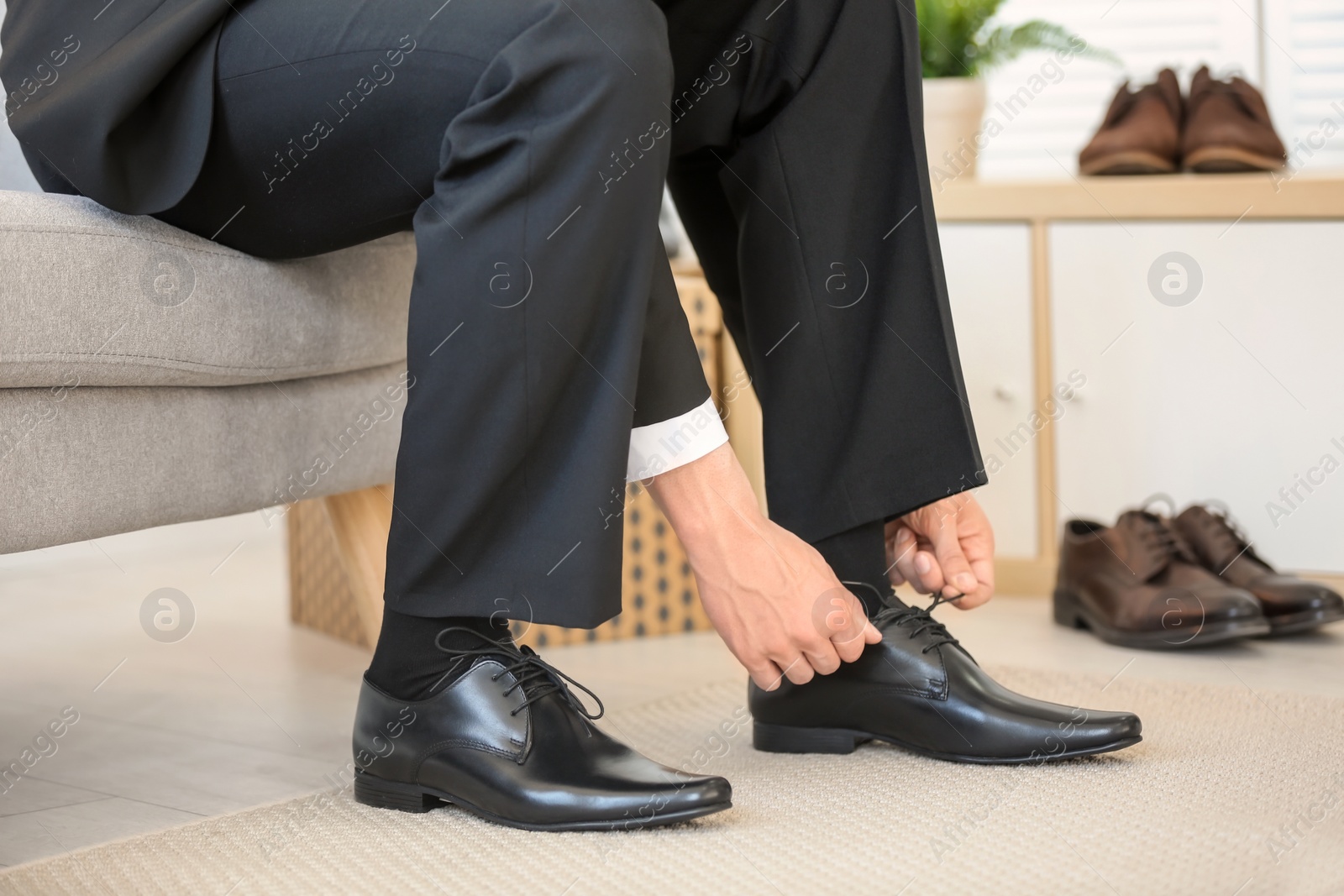 Photo of Young man trying on shoes in store