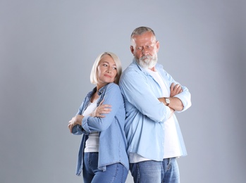 Photo of Upset mature couple on grey background. Relationship problems