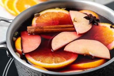 Photo of Delicious hot mulled wine in pot, closeup