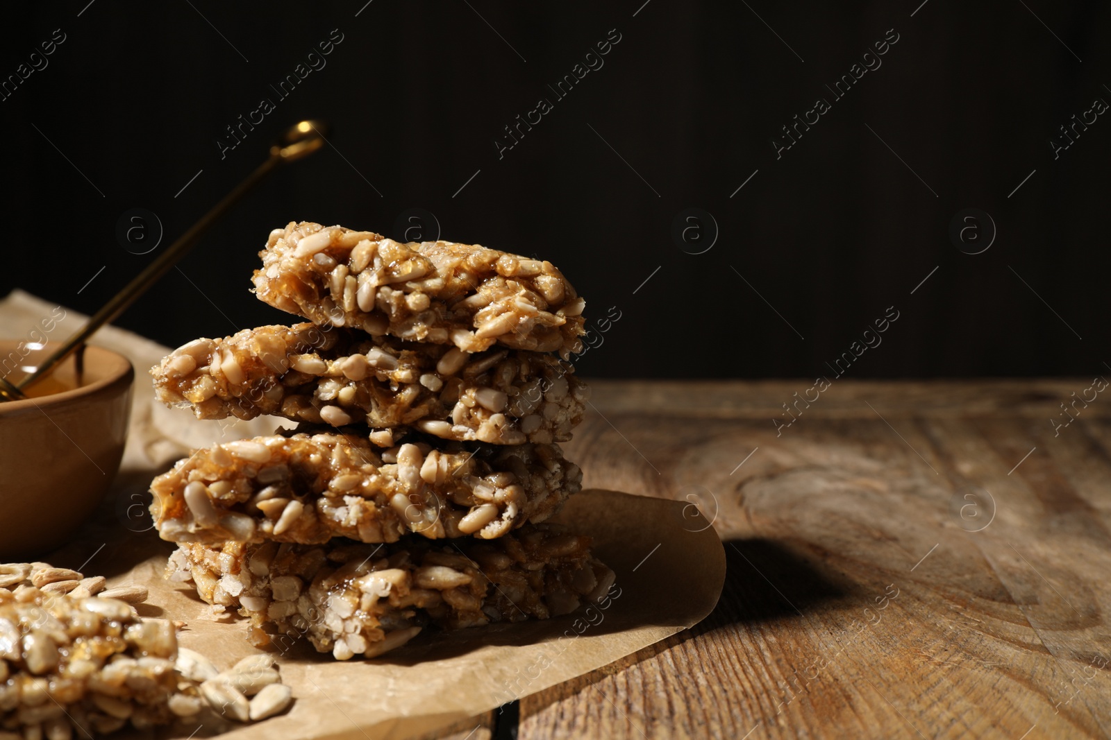 Photo of Delicious sweet kozinaki pieces on wooden table. Space for text