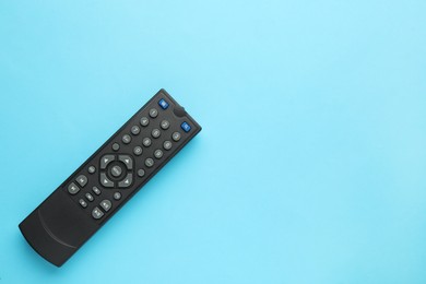 Photo of Remote control on light blue background, top view. Space for text