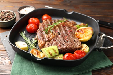 Photo of Delicious grilled beef steak and vegetables served on wooden table, closeup