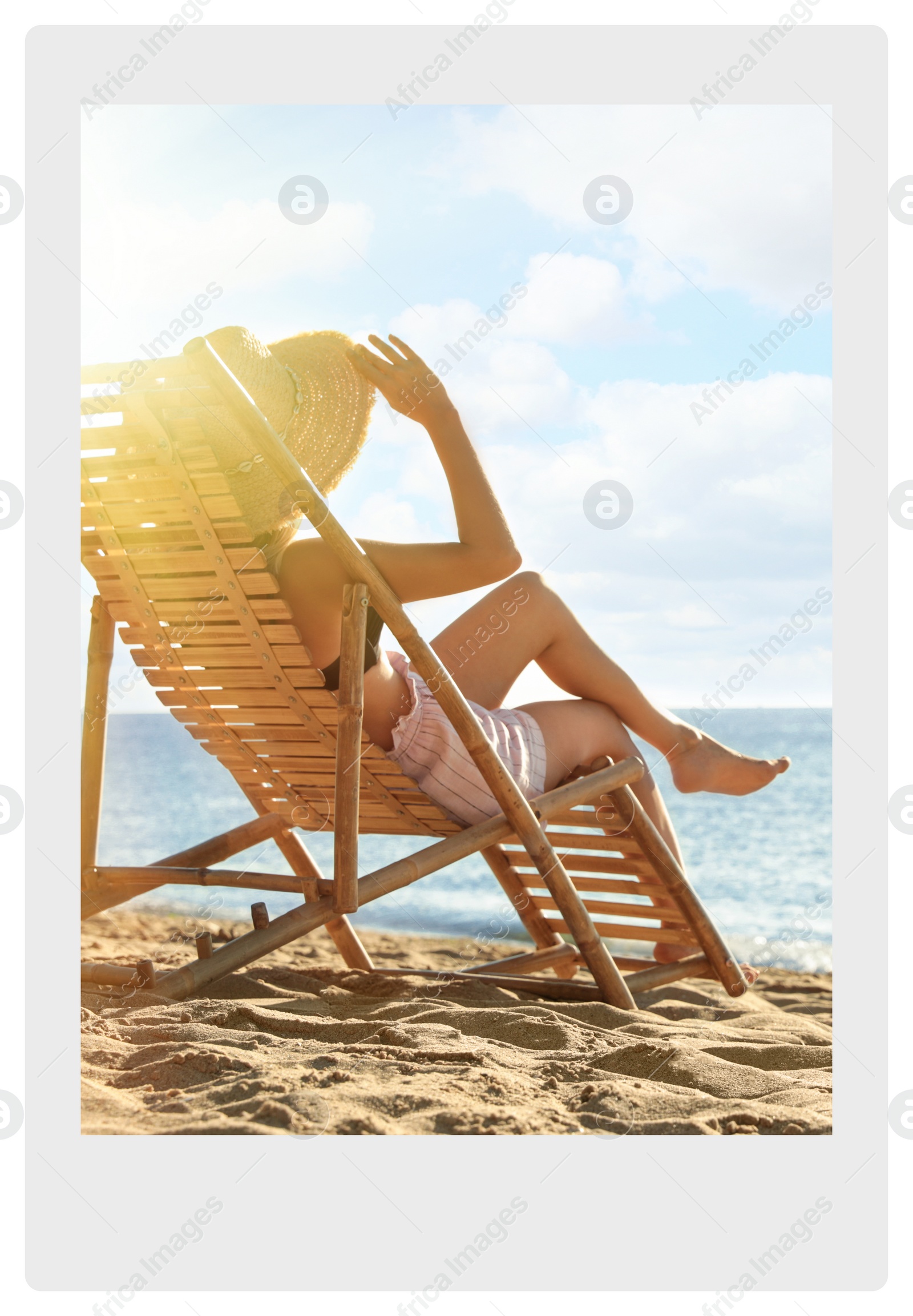 Image of Paper photo. Woman relaxing on deck chair at sandy beach 