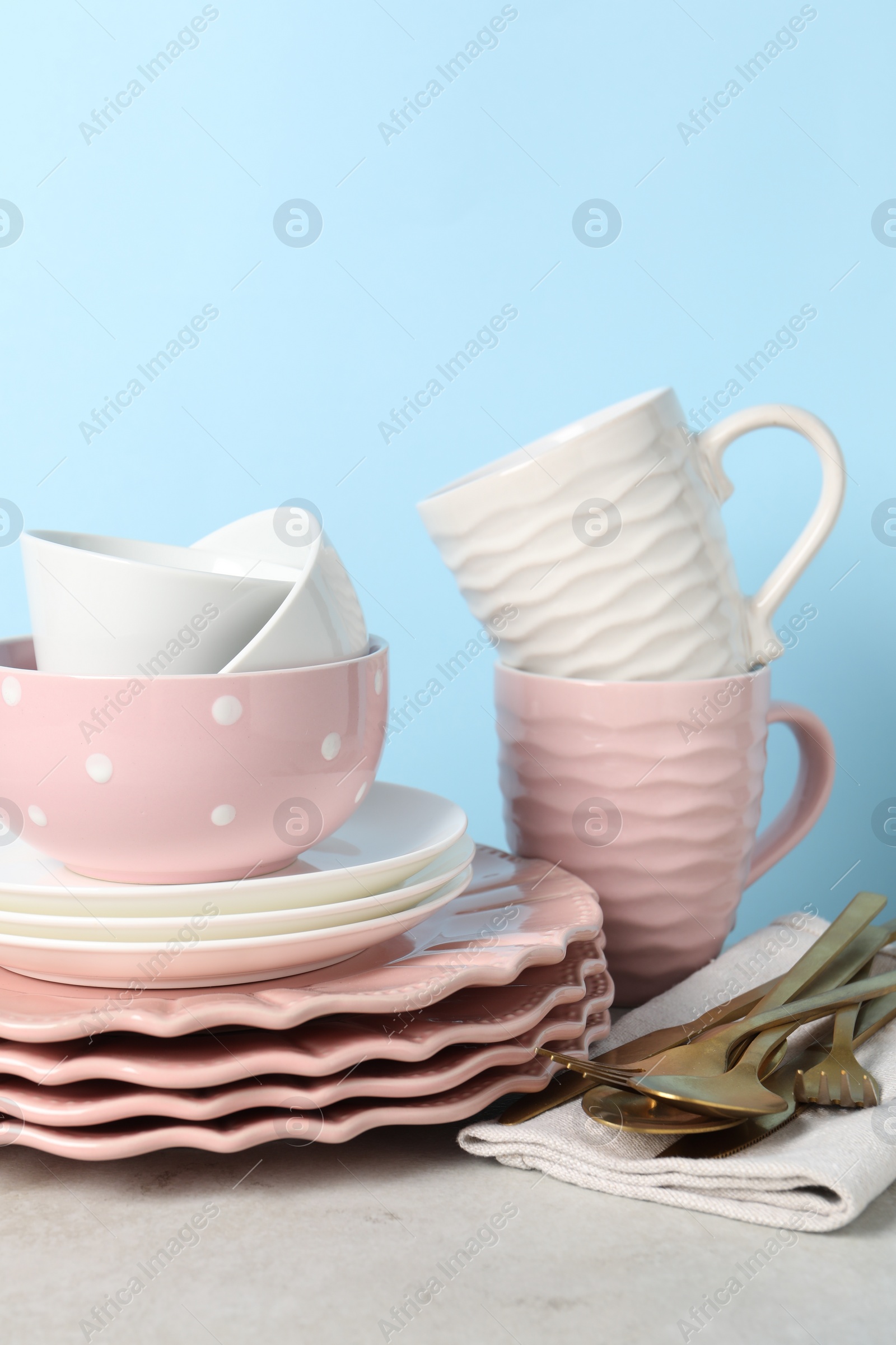 Photo of Beautiful ceramic dishware, cups and cutlery on light grey table