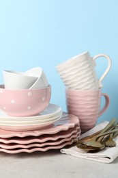 Photo of Beautiful ceramic dishware, cups and cutlery on light grey table