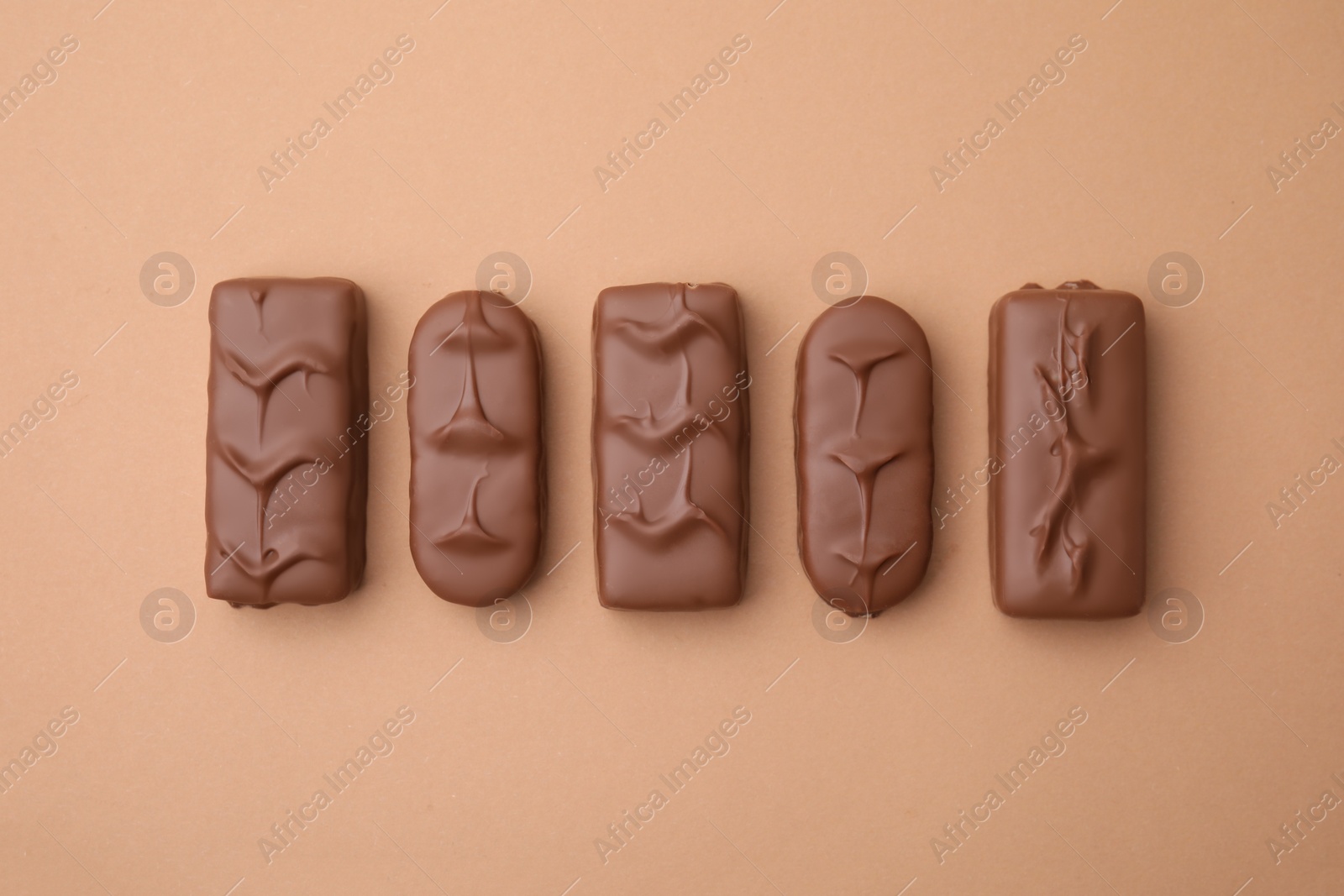 Photo of Different tasty chocolate bars on beige background, flat lay