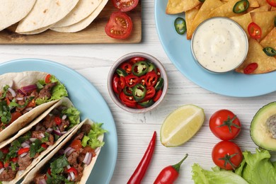 Photo of Flat lay composition with delicious tacos on wooden table