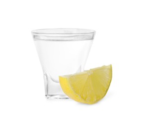 Photo of Shot glass of vodka and lemon isolated on white