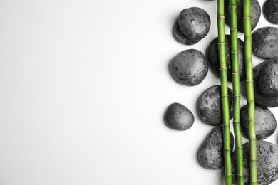 Photo of Wet zen stones and bamboo on white background, top view with space for text