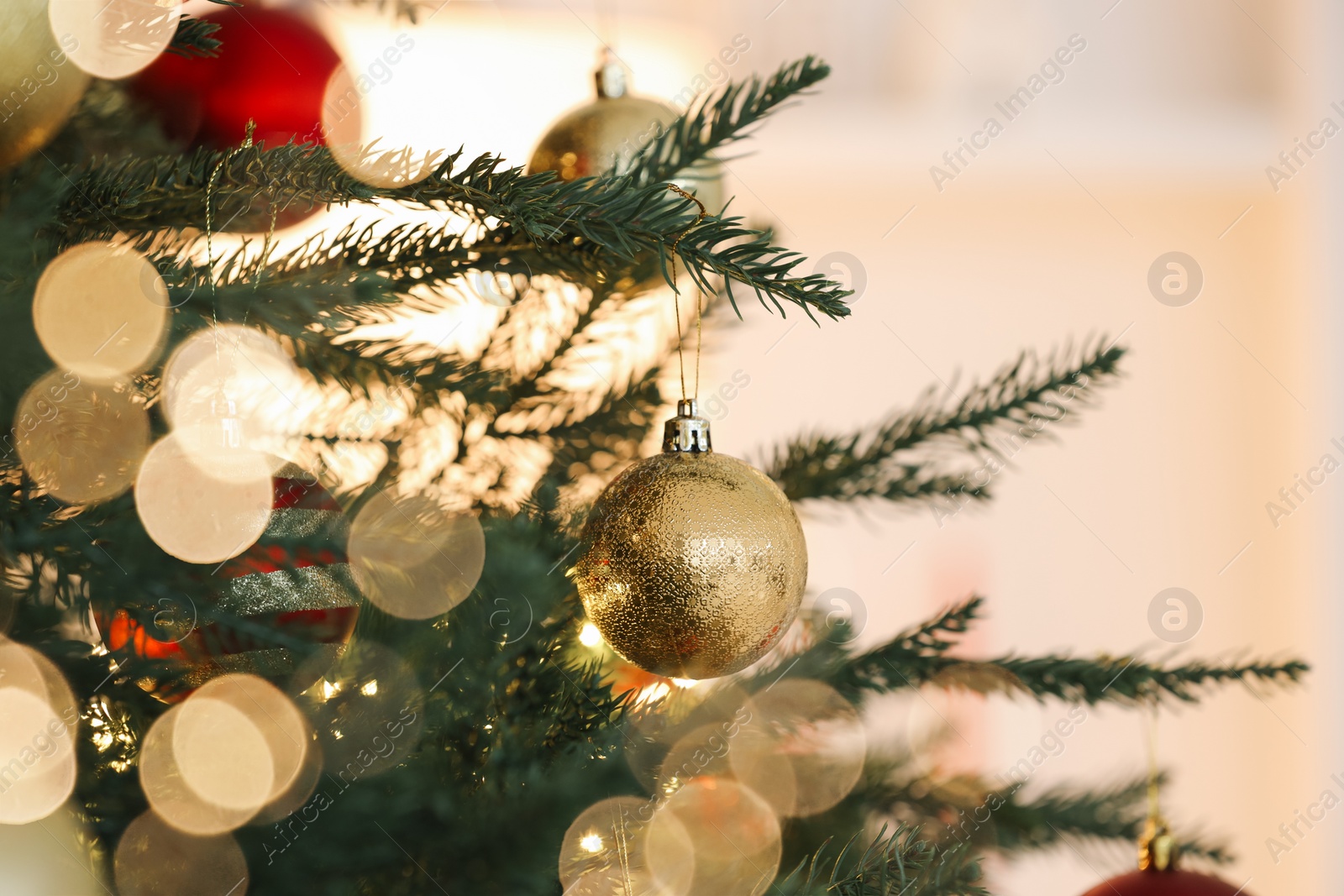 Photo of Christmas tree decorated with festive balls on light background, closeup