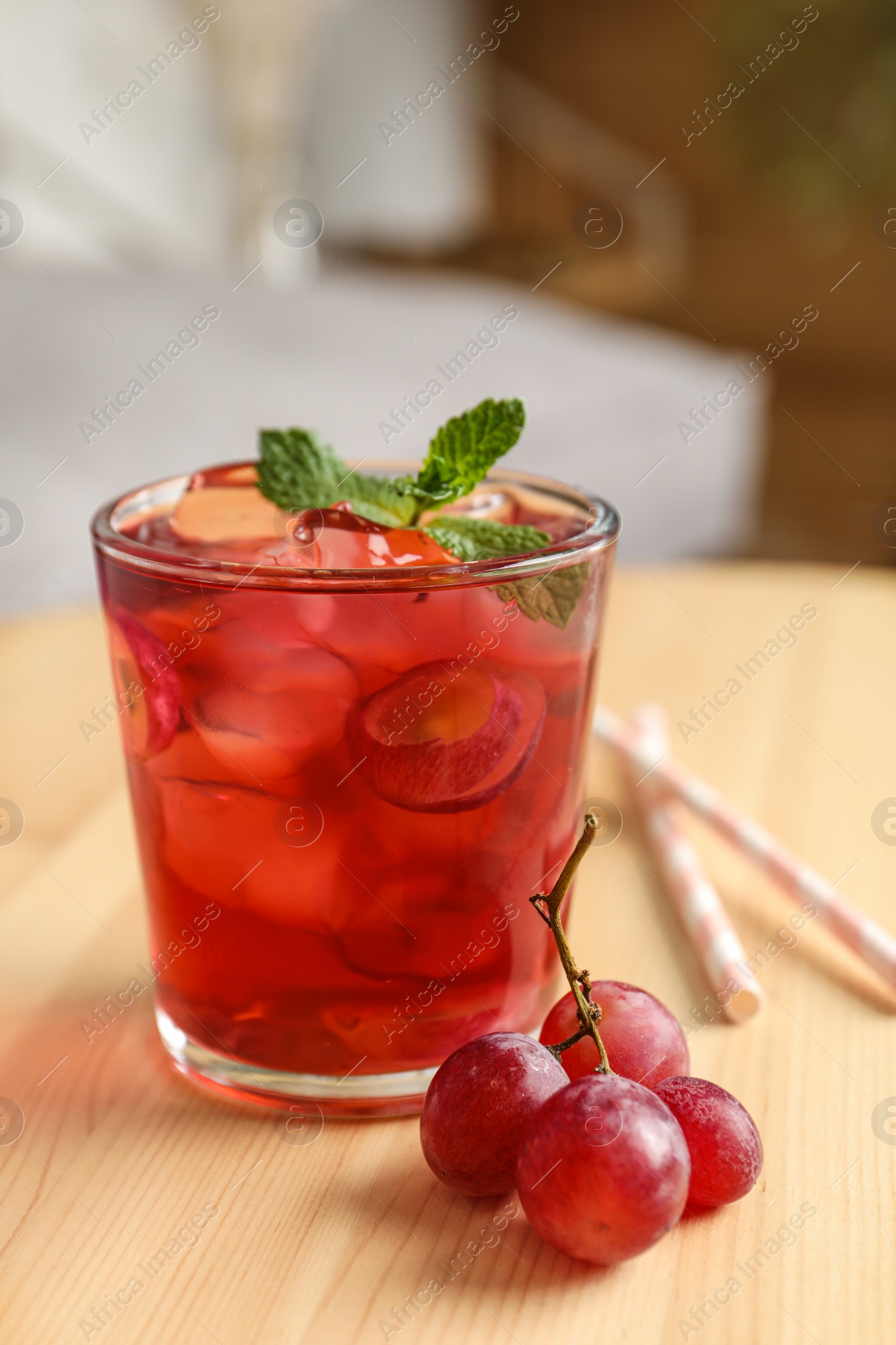 Photo of Soda water with grapes, ice and mint on wooden table indoors. Refreshing drink