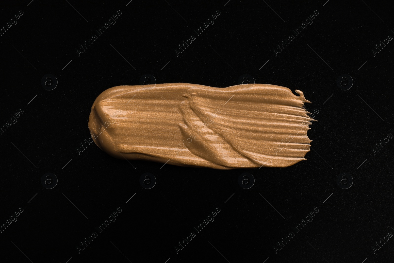 Photo of Golden paint brush stroke on black background