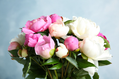 Photo of Bouquet of beautiful peonies on light blue background, closeup