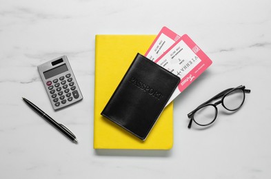 Photo of Flat lay composition with tickets, passport and calculator on white marble table. Business trip