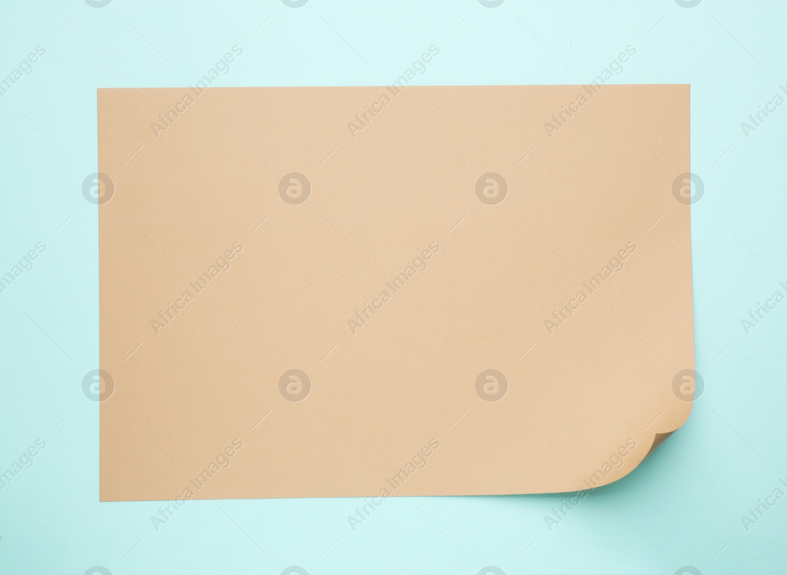 Photo of Sheet of brown paper on light blue background, top view