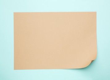 Sheet of brown paper on light blue background, top view