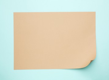 Photo of Sheet of brown paper on light blue background, top view