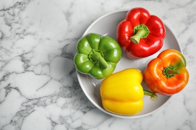 Photo of Bowl with ripe paprika peppers on table, top view