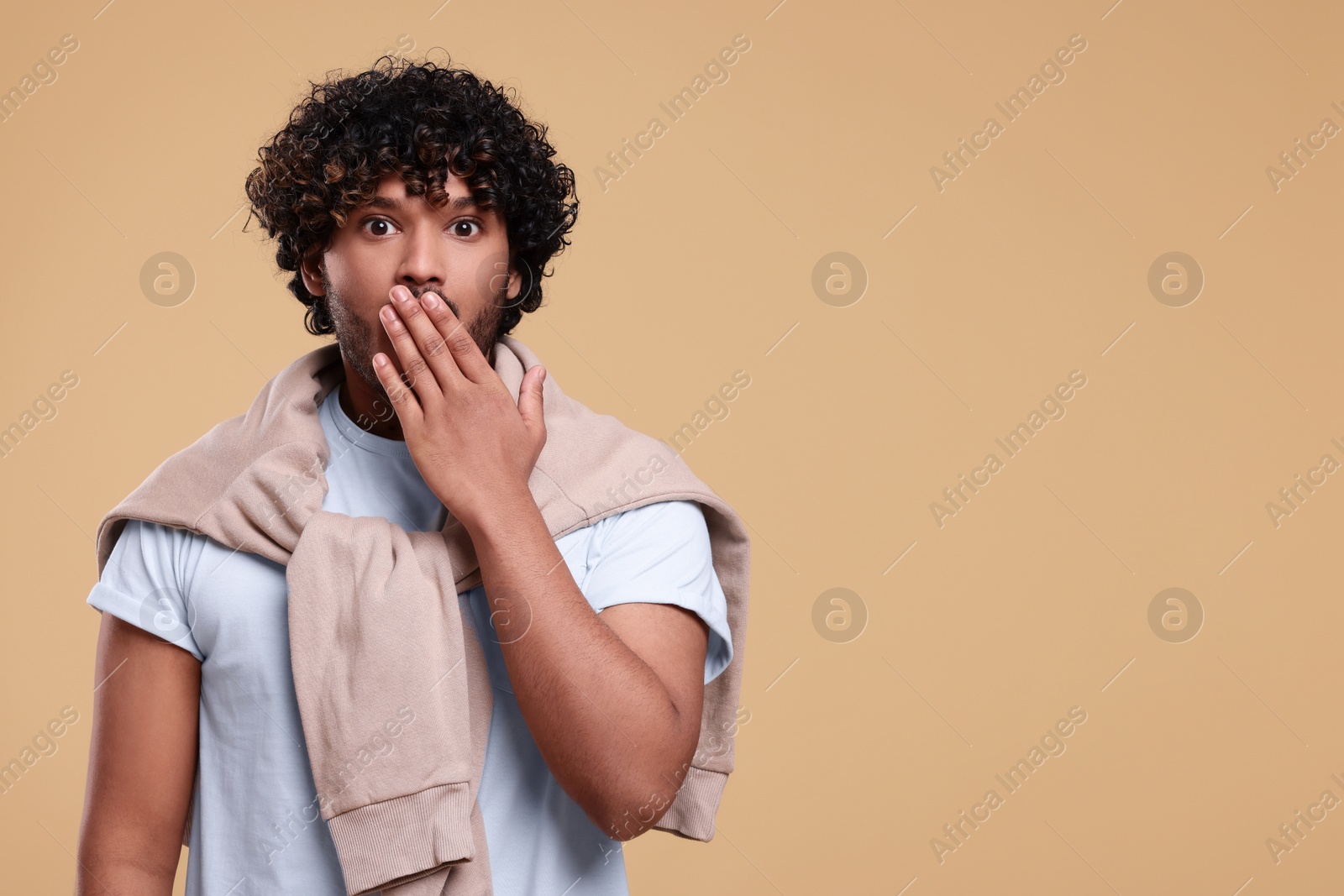 Photo of Handsome surprised man on beige background, space for text