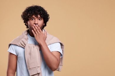 Photo of Handsome surprised man on beige background, space for text