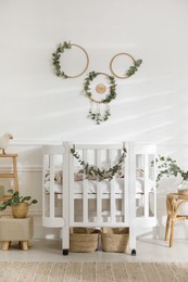 Stylish baby room decorated with eucalyptus branches