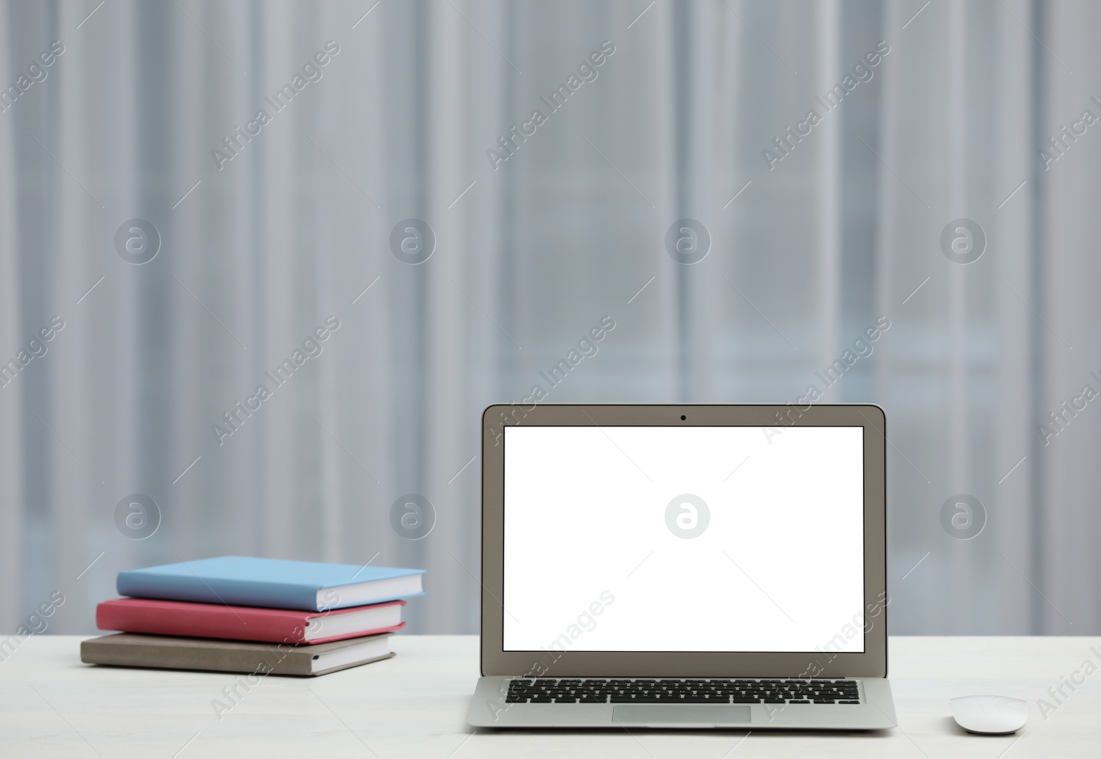 Photo of Laptop with blank screen on table indoors. Space for text