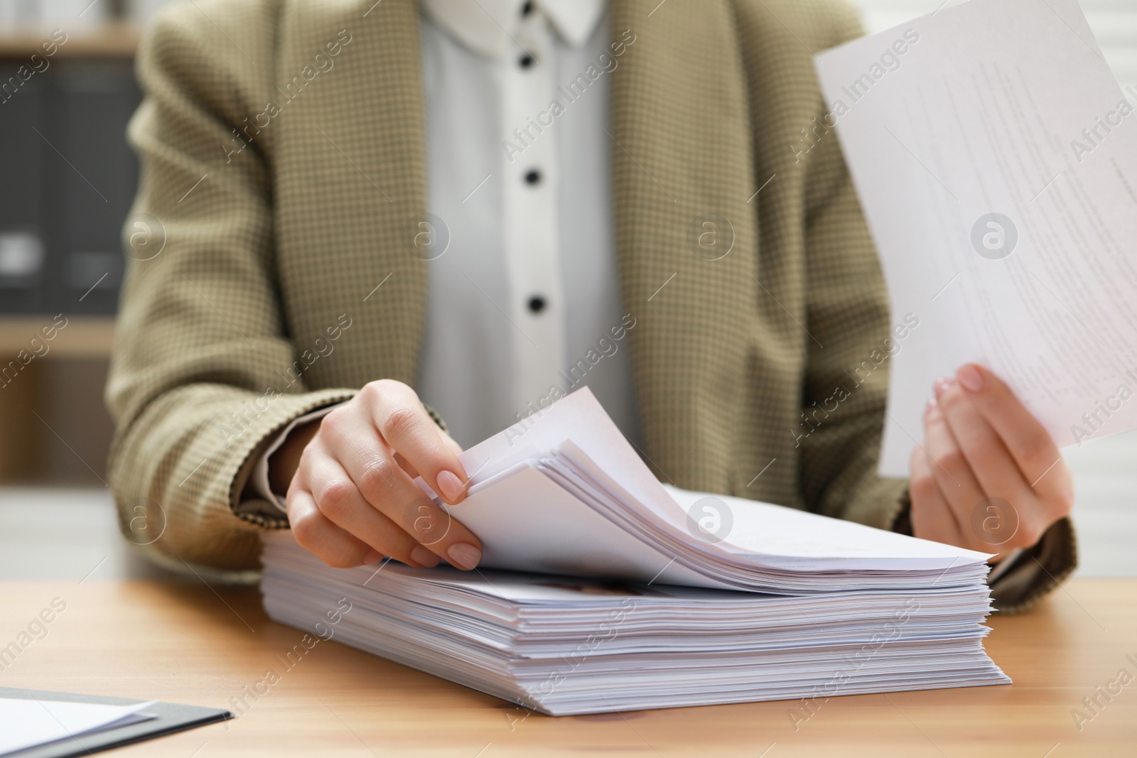 Photo of Woman working with documents at table in office, closeup