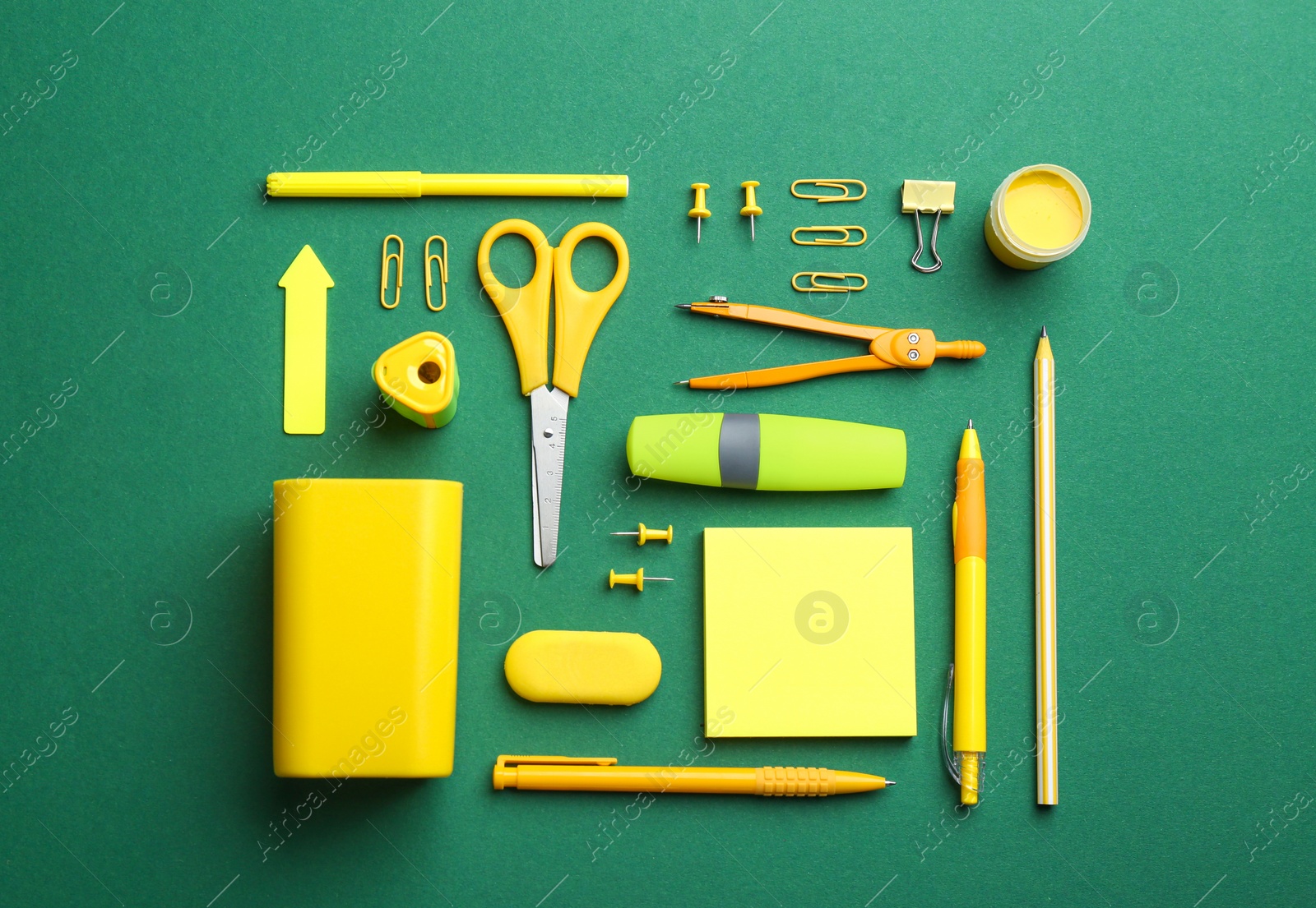 Photo of Bright school stationery on green background, flat lay