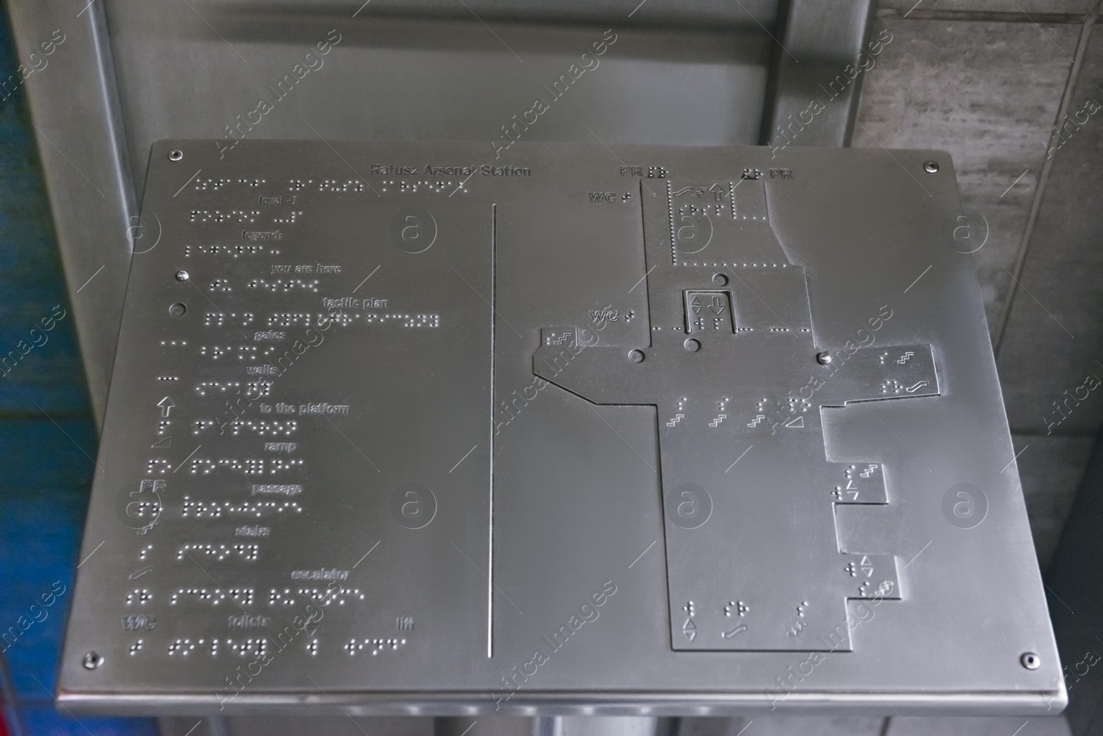 Photo of Silver stand with Braille text and building plan indoors, closeup