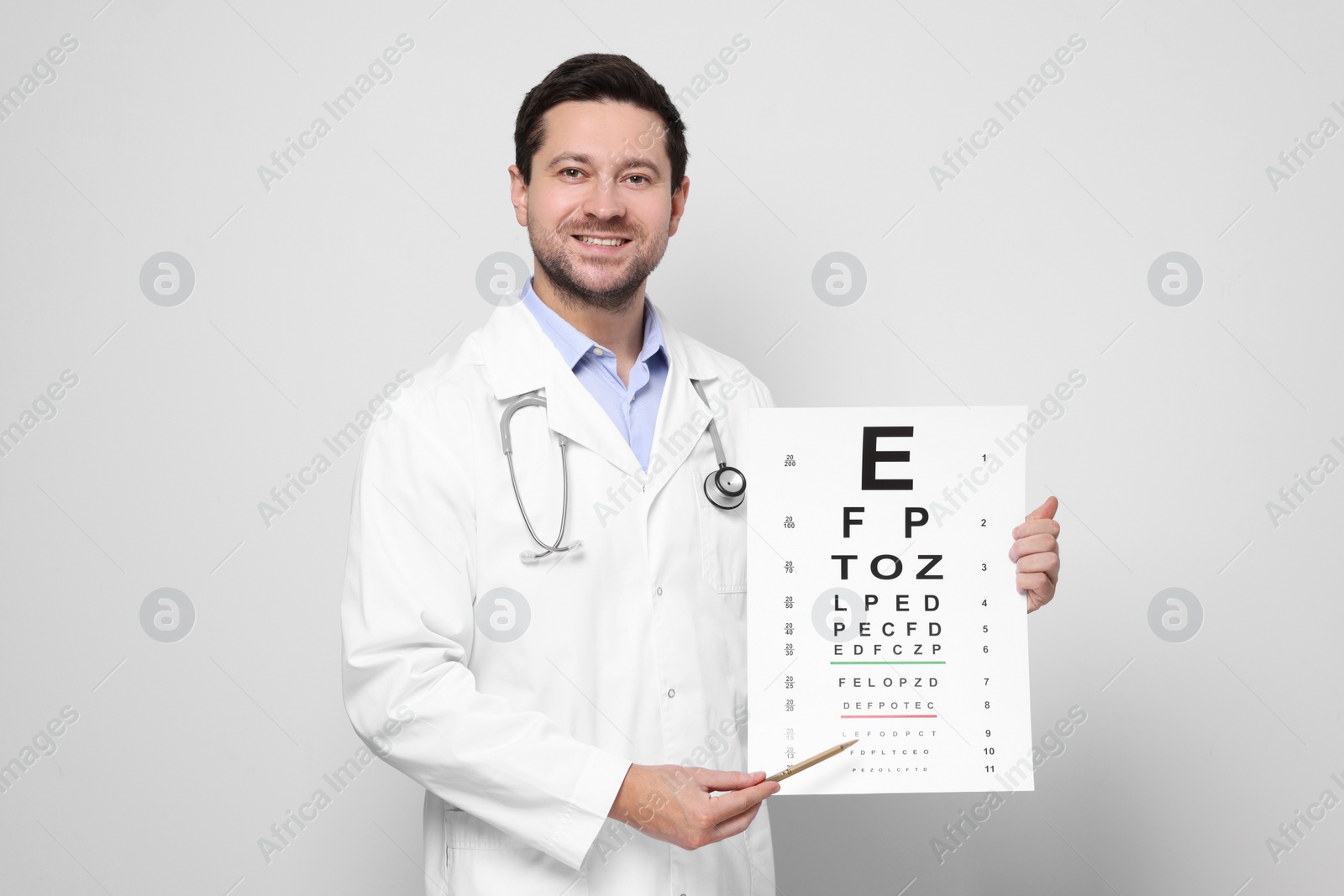 Photo of Ophthalmologist pointing at vision test chart on light background