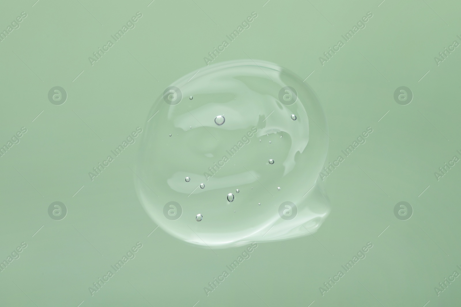 Photo of Sample of cleansing gel on pale green background, top view. Cosmetic product