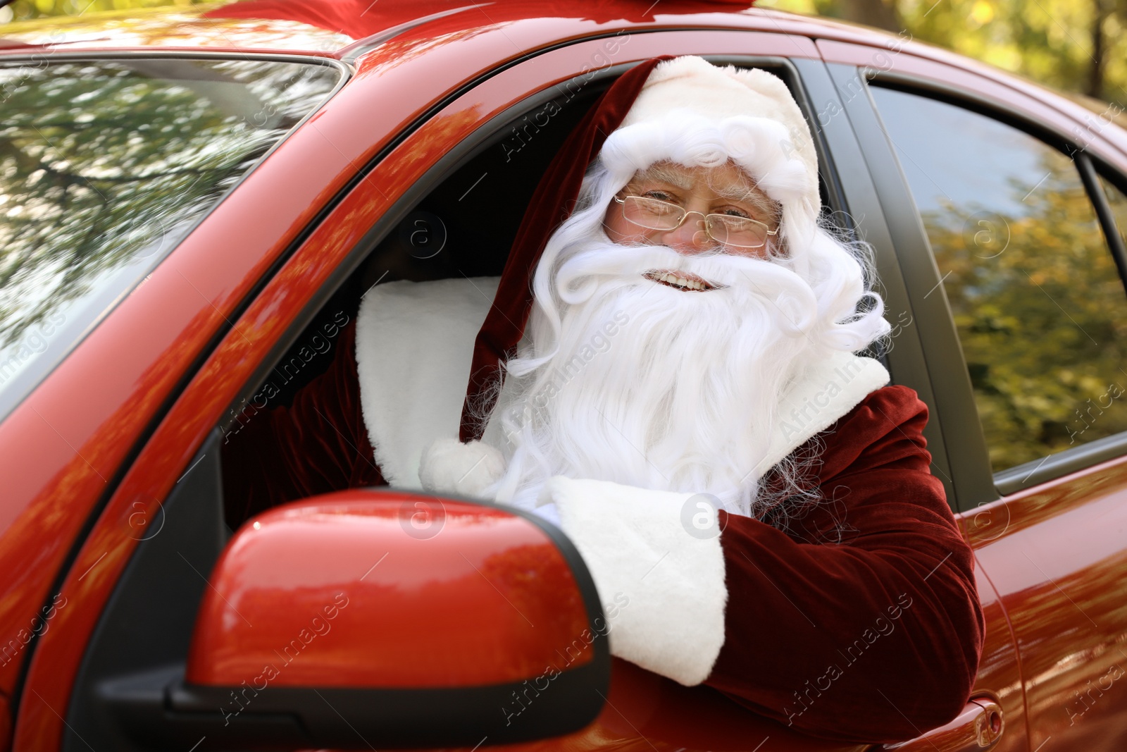 Photo of Authentic Santa Claus driving his modern car, outdoors