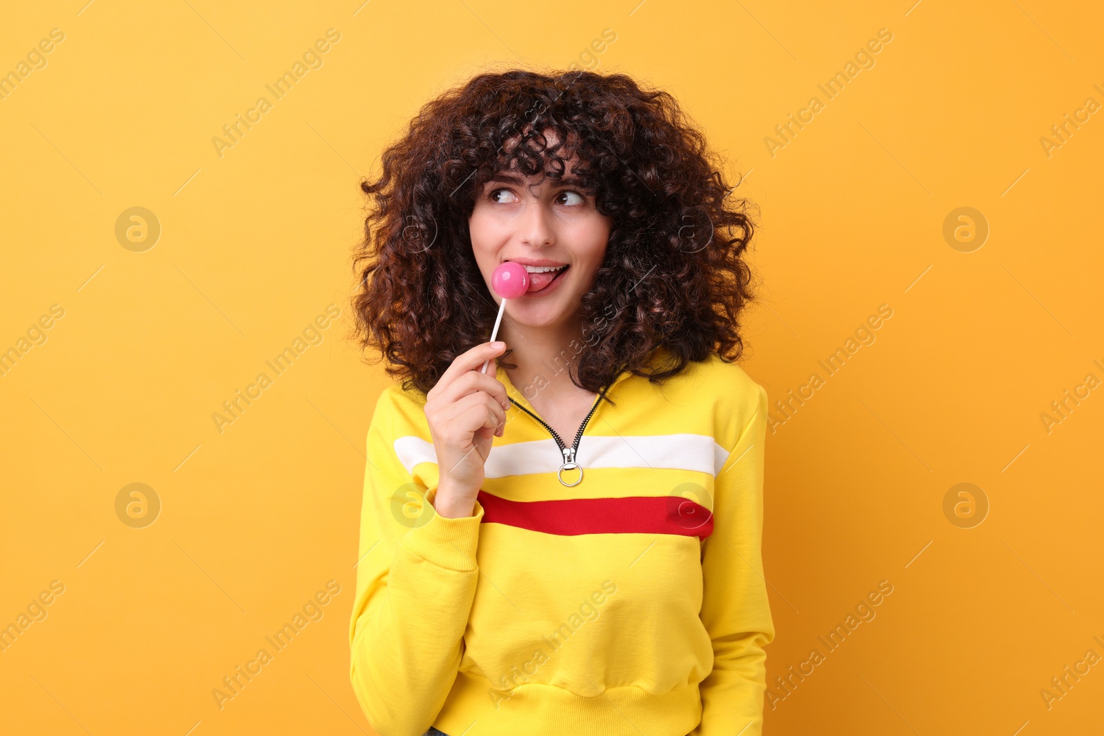 Photo of Beautiful woman with lollipop on yellow background