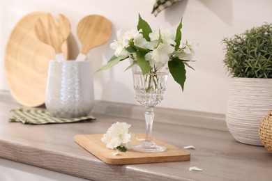 Photo of Beautiful jasmine flowers on wooden table indoors