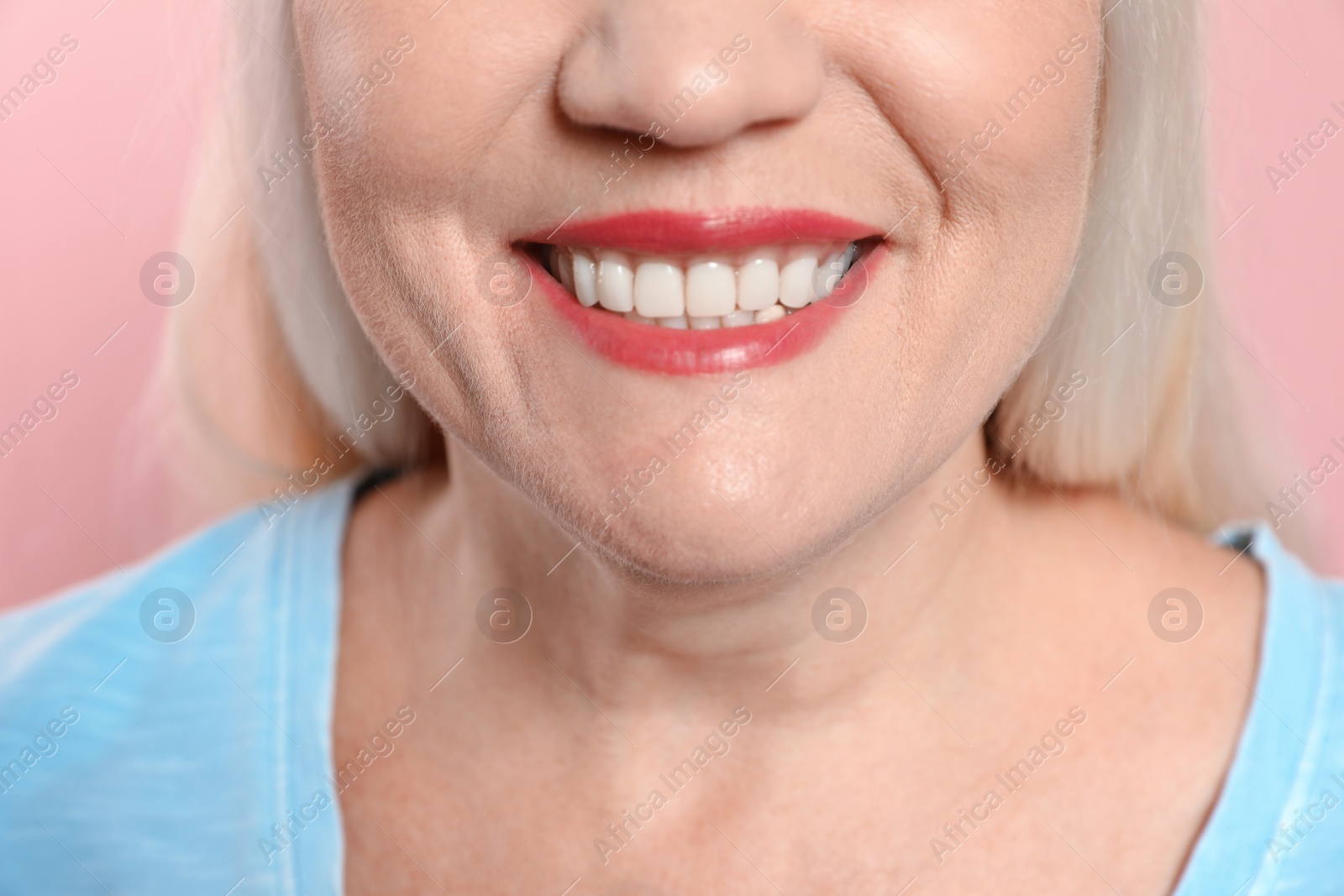 Photo of Smiling woman with perfect teeth on color background, closeup